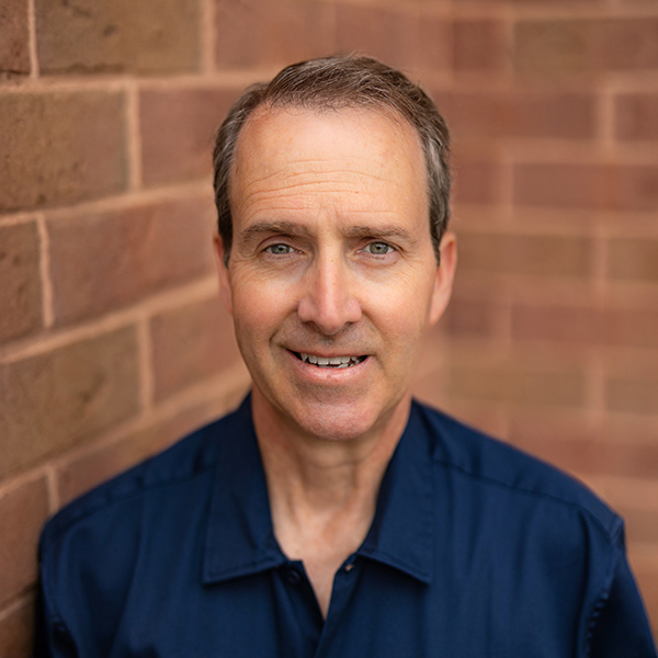 Photo of Trent Langton, Plant Operations Director of University Senior Living, smiling against a brick background.