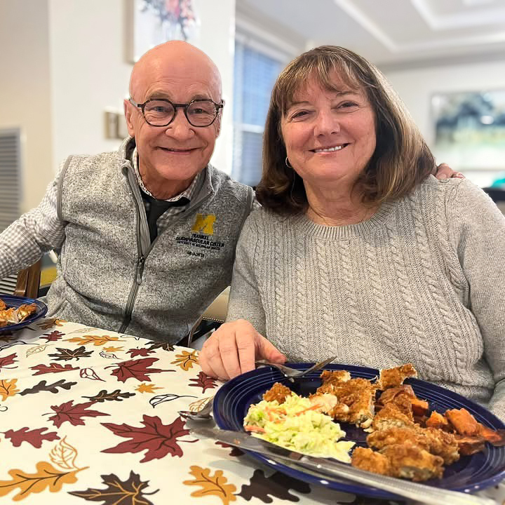 A man and woman smile while enjoying a meal at University Senior Living.