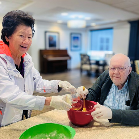 A man and woman at University Senior Living smile while enjoying a project.
